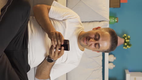 Vertical-video-of-Man-texting-with-happy-expression-with-his-girlfriend.